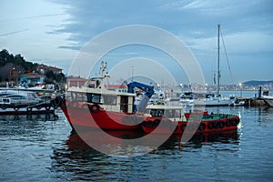 Evening at the Harbor: Red Fishing Boat and Sailboats