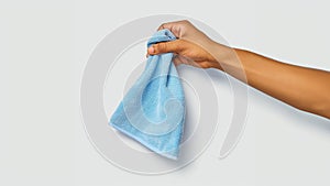 arm holding light blue microfiber cloth
