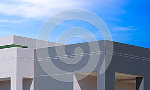 Roughness concrete wall of geometric gray and white office building in modern and minimal style against blue sky background photo