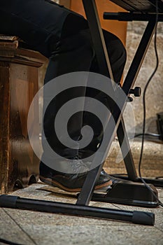 Image of a man\'s foot using the sustain pedal on the piano keyboard while playing music. photo