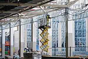 Workers pulling electrical cables on cable trays workung at height
