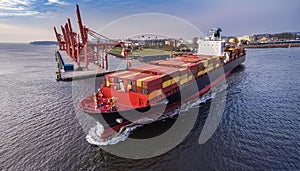 Container ship in port terminal - huge freighter fully loaded