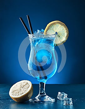 Blue cocktail with lemon, on blue