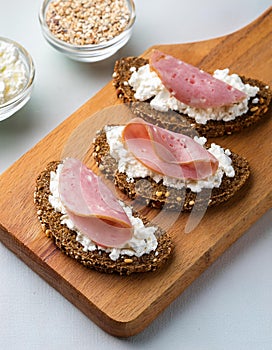 Crispy rye bread with sesame seeds, ham and cottage cheese.