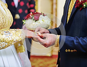 The groom places the wedding ring on the bride s finger
