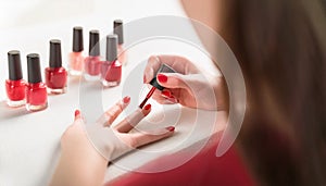 Applying nail polish. Woman applying red nail polish