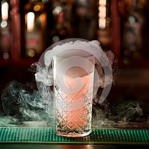 Cocktail with ice vapor on bar desk, close-up