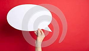Woman holding blank speech bubble on red background, closeup. Space for text