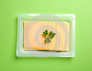 Pack of sliced, Cheese on green background, top view