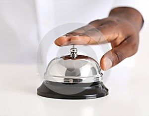 Man ringing hotel service bell at light table
