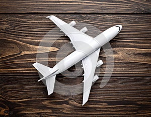 Toy airplane on wooden background, top view.