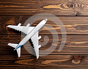 Toy airplane on wooden background, top view.