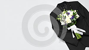 Beautiful wedding bouquet and groom on light background