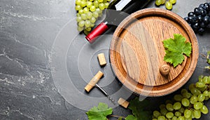 Corkscrew, wine bottle, grapes, cork and wooden barrel on grey table, top view