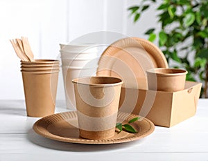 Set of disposable tableware on white wooden table