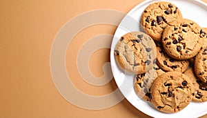 Chocolate chip cookies on white plate on matte light brown gradient background