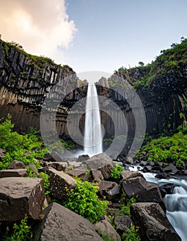 Wide shot of waterfall with dramatic rock formations