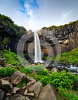 Wide shot of waterfall with dramatic rock formations