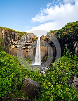 Wide shot of waterfall with dramatic rock formations