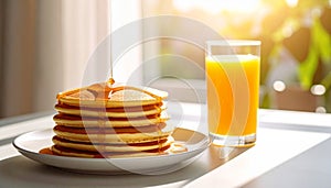 Three-quarter angle pancakes with honey drizzle and orange juice