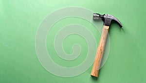 Matte soft green background with one small hammer in a corner