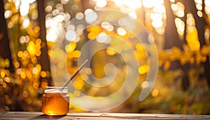 Warm autumn forest bokeh with tiny jar of honey in bottom-left corner