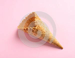 Empty wafer ice cream cone on pale pink background
