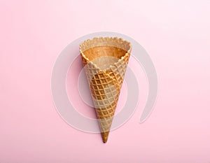 Empty wafer ice cream cone on pale pink background