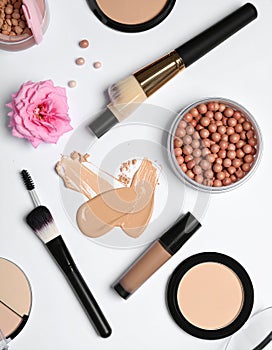 Various makeup products arranged on a white surface.
