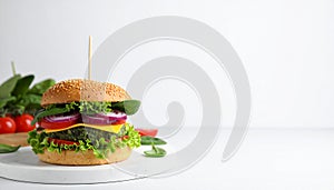 Tasty vegetarian burger with spinach cutlet, cheese and vegetables on white table