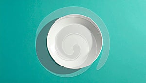 White Ceramic Plate Centered on Teal Background with Shadow