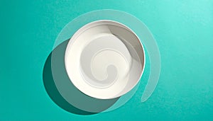 White Ceramic Plate on Turquoise Blue Background with Shadow