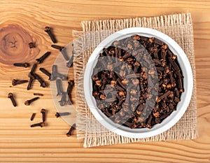 Bowl of Cloves on Wooden Background