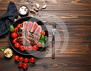 Delicious cooked meat, tomatoes and basil on a wooden table, flat lay. Text area
