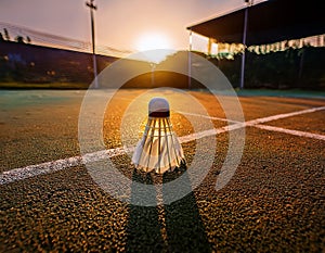Shuttlecock hitting badminton racket with motion dust and dark background