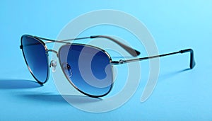 Stylish sunglasses on blue background. Fashionable accessory