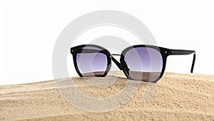 Stylish sunglasses on sand against white background. Space for text