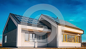 Modern house with solar panels on the roof under blue sky
