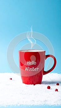 Red mug with words Hello winter on the blue background.