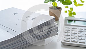 Stack of Documents and Calculator on Desk