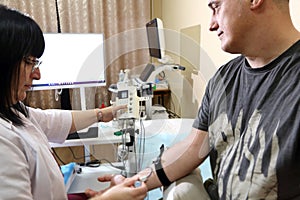 Electromyography. A man undergoes an examination on an electromyograph.