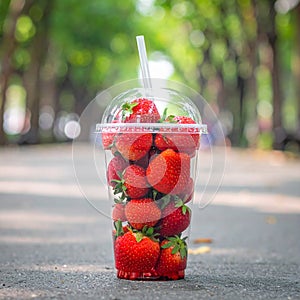 Soft Focus Strawberry in plastic cup in a park.- (Selective focus)
