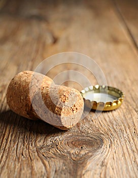 Cork of sparkling wine and muselet cap on wooden table, closeup. Space for text