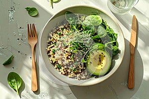 Healthy quinoa bowl with avocado, spinach, and microgreens in bright natural sunlight on a rustic table â AI-Generated
