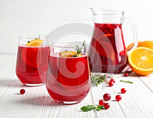 Glasses and jug of Red Sangria on white wooden table