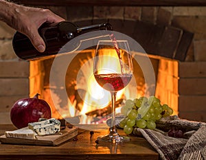 Art pouring wine by the fireplace