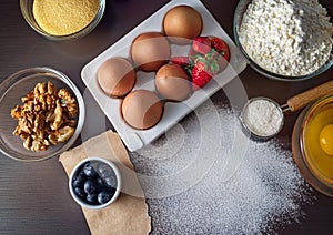 Assorted baking ingredients arranged on a dark wooden surface.