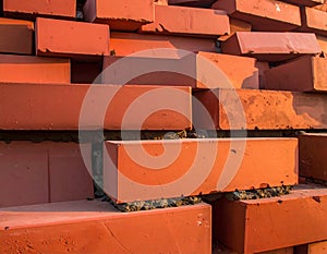 A close-up view of red clay bricks stacked in an interlocking pattern