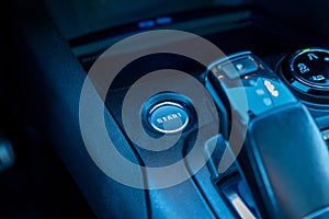 Close-up of a car start engine button and central console with gear shift