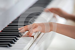 Close-up of hands of a child playing the piano.
